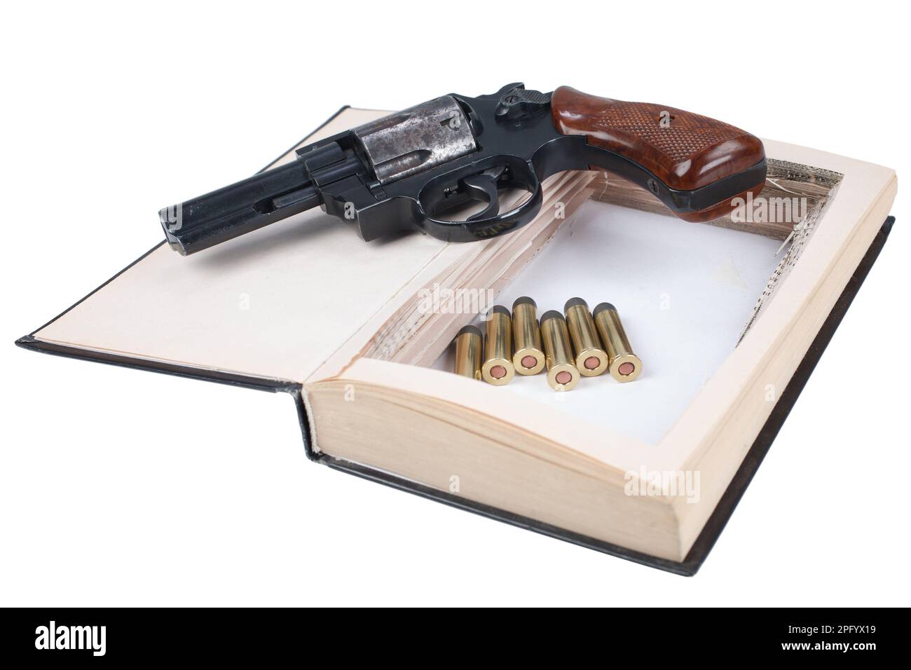 Revolver gun with cartridges hidden in a book isolated on white background Stock Photo