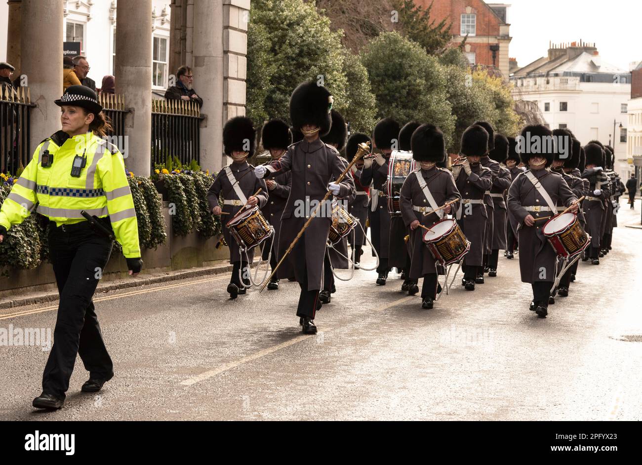 Windsor, Berkshire, England, UK. 2023. Corps of Drums, 1st Battalion Welsh Guards led by a policewoman marching past the Guidhall in Windsor, UK. Stock Photo