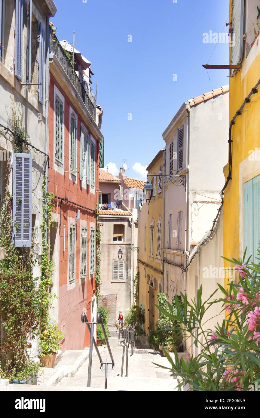 Colorful houses lining narrow streets in Marseille with warm sunlight and blue sky Stock Photo