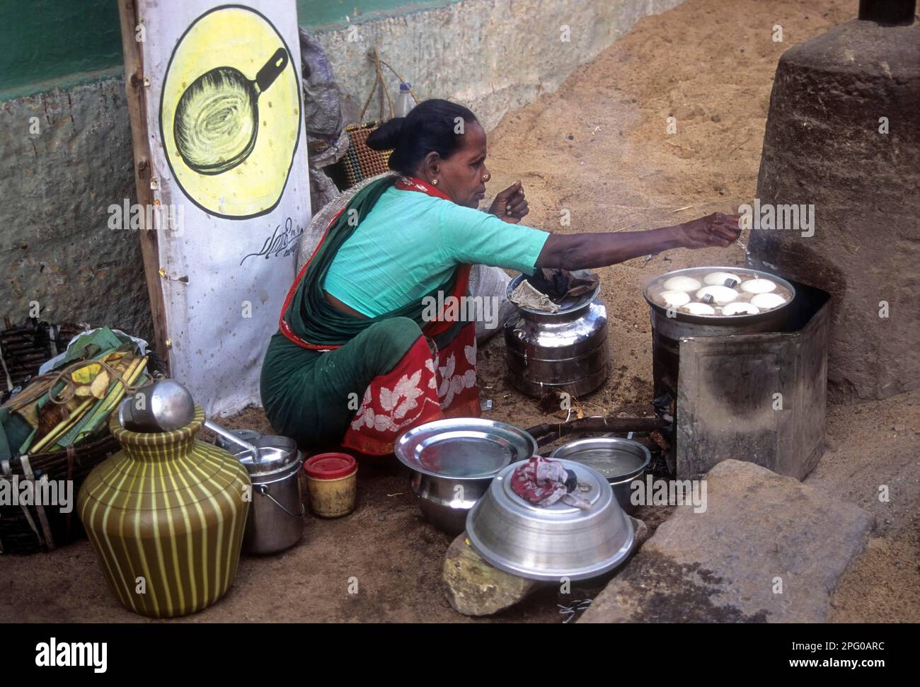 An old woman preparing idlis; idlys on the side of the road at Madurai, Tamil Nadu, India Stock Photo