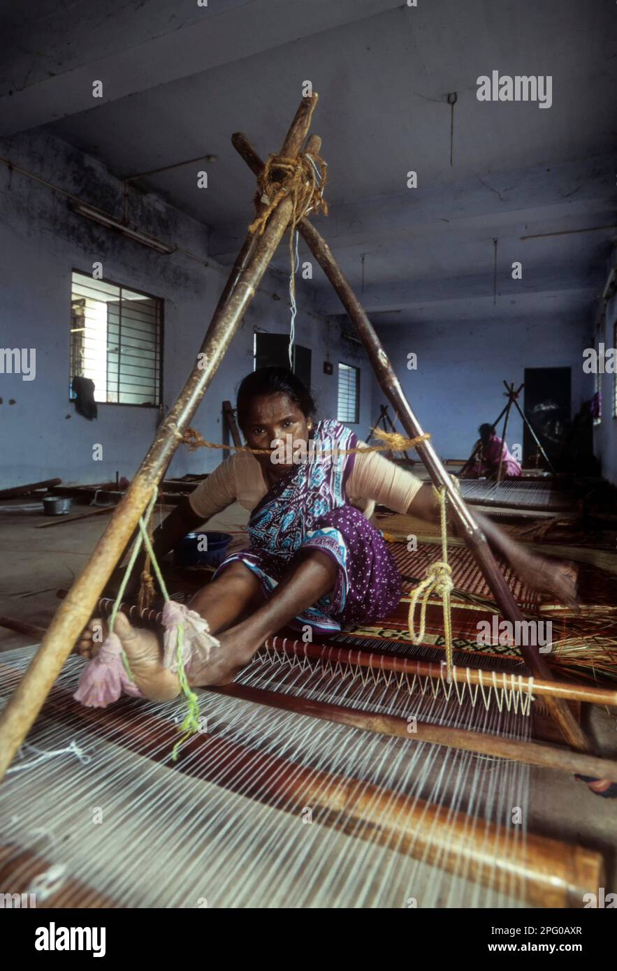 A woman weaving korai or cyperus mat in Pathamadai, Tamil Nadu, India