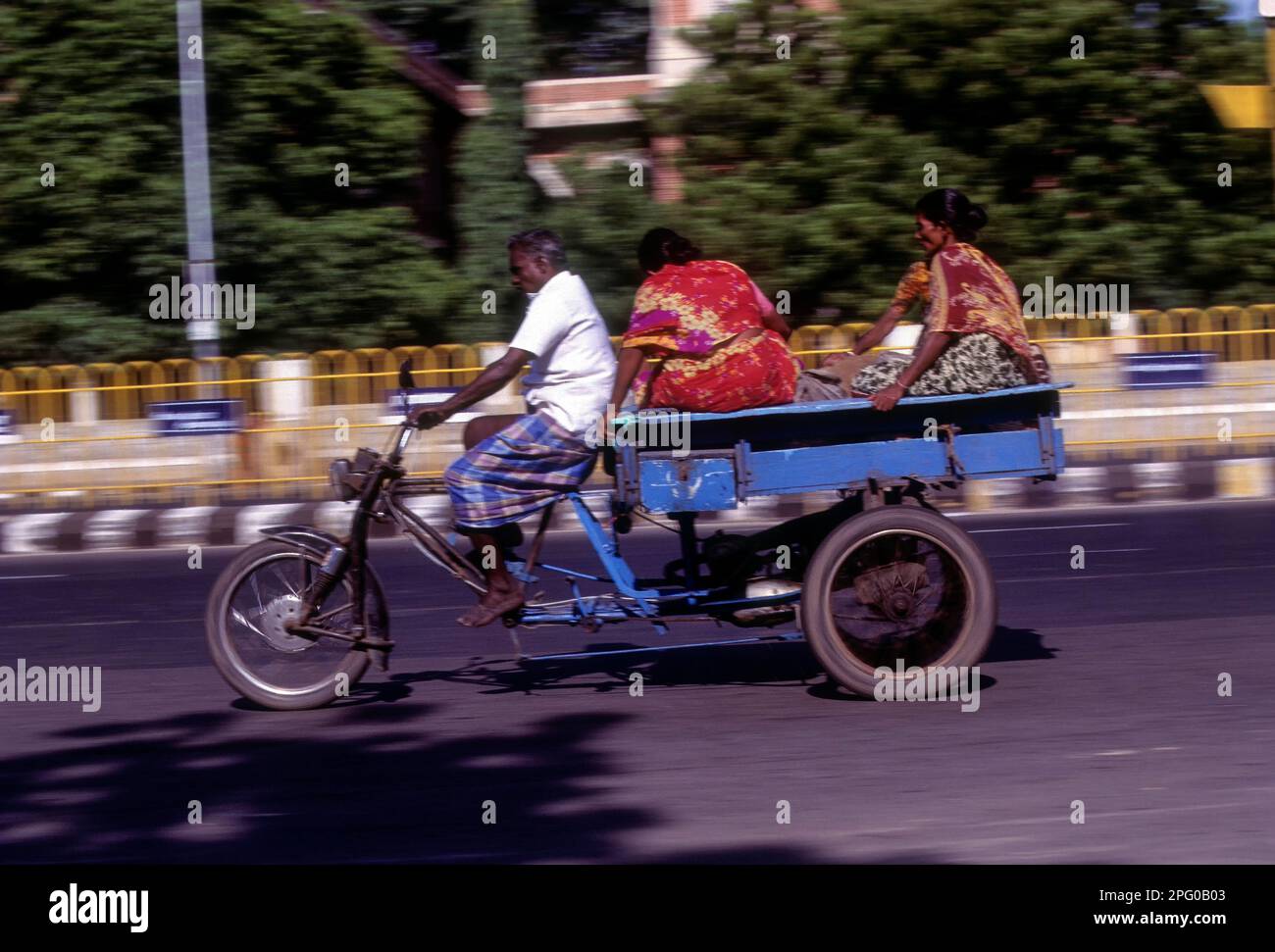 People journeying on a tricycle on the beach road in Chennai, Tamil Nadu, India, Asia Stock Photo