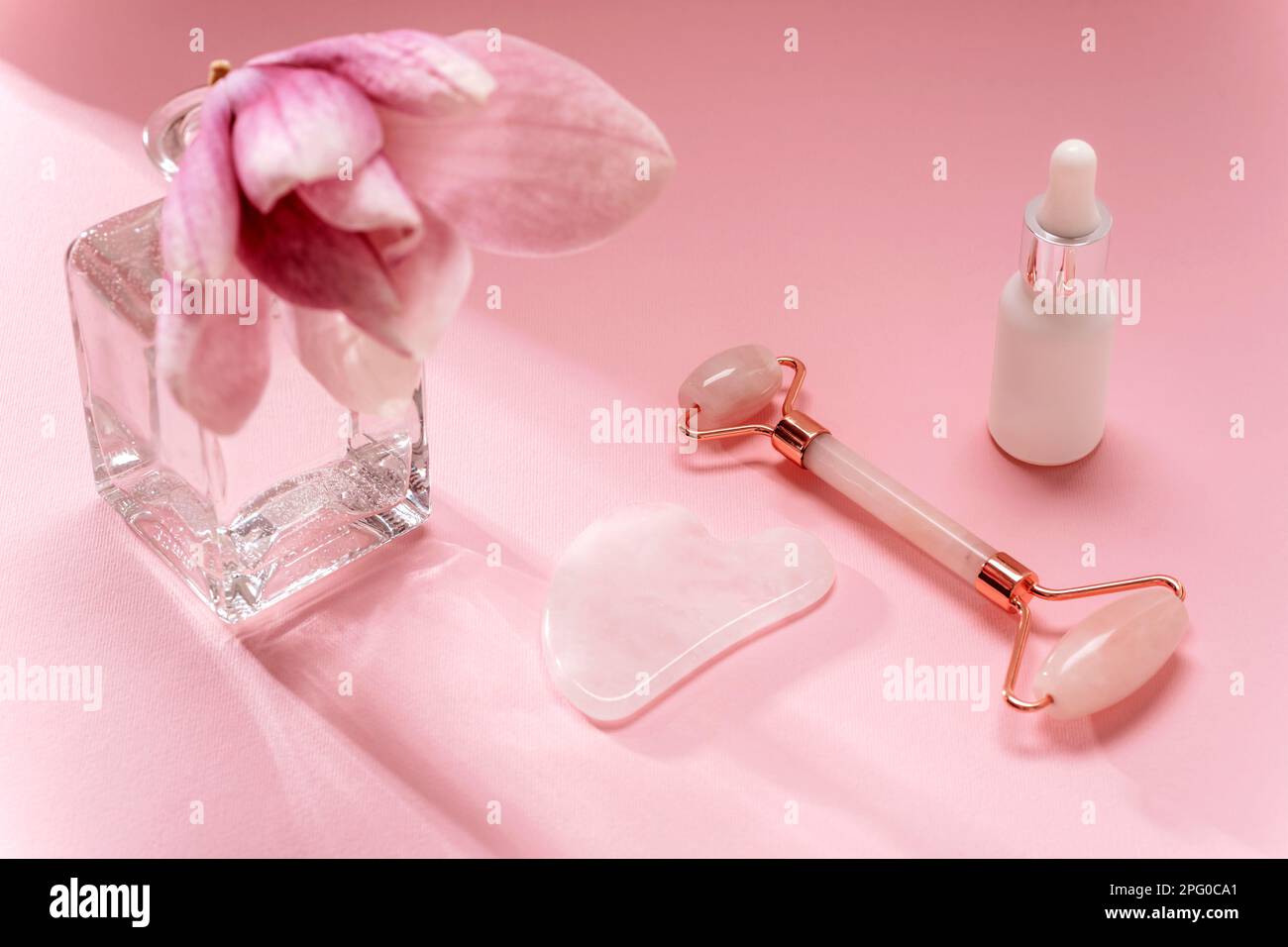Rose quartz crystal facial roller and gua sha scraper, face serum and