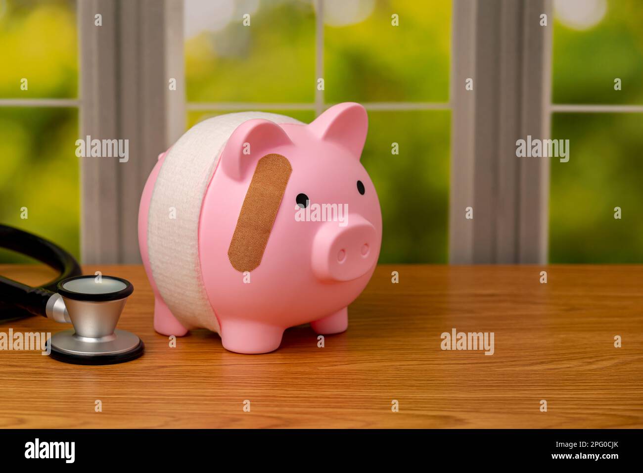 Piggy bank with bandage and stethoscope. Health care costs, medical