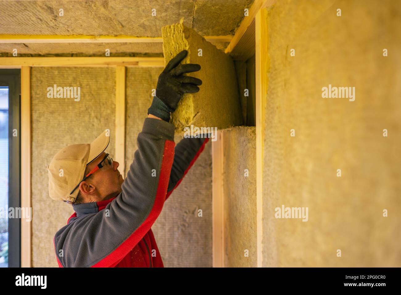 Contractor Installing High Temperature Mineral Wool Inside Garden Shed Walls. Stock Photo