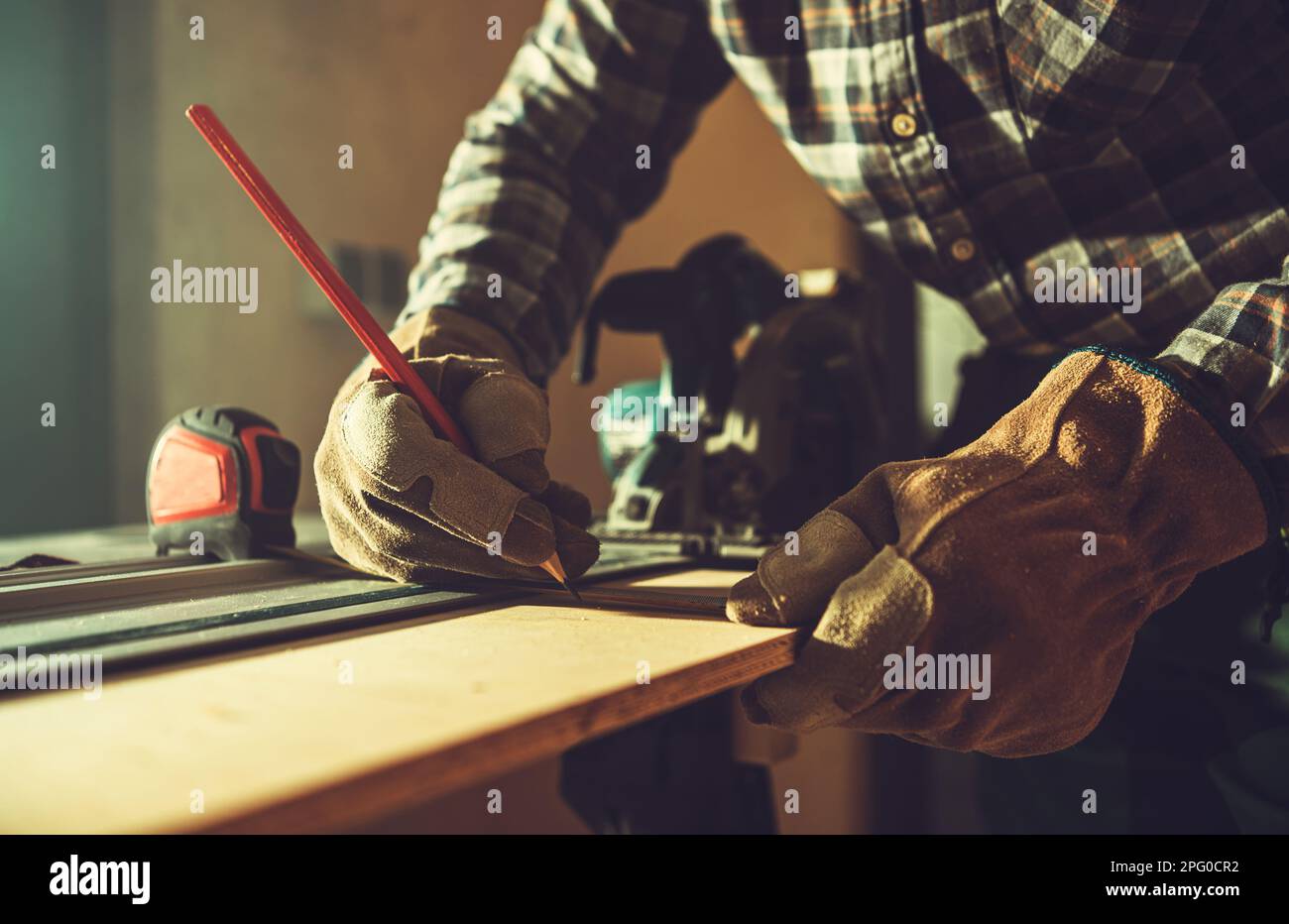 General Construction Worker Working on His Woodwork Project Inside a Small Shed. Stock Photo
