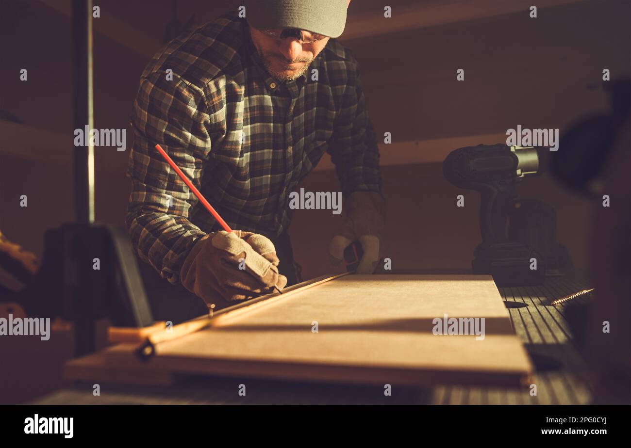 Caucasian Woodwork Artisan and His Small Wood Project Inside a Shed Workplace. Stock Photo