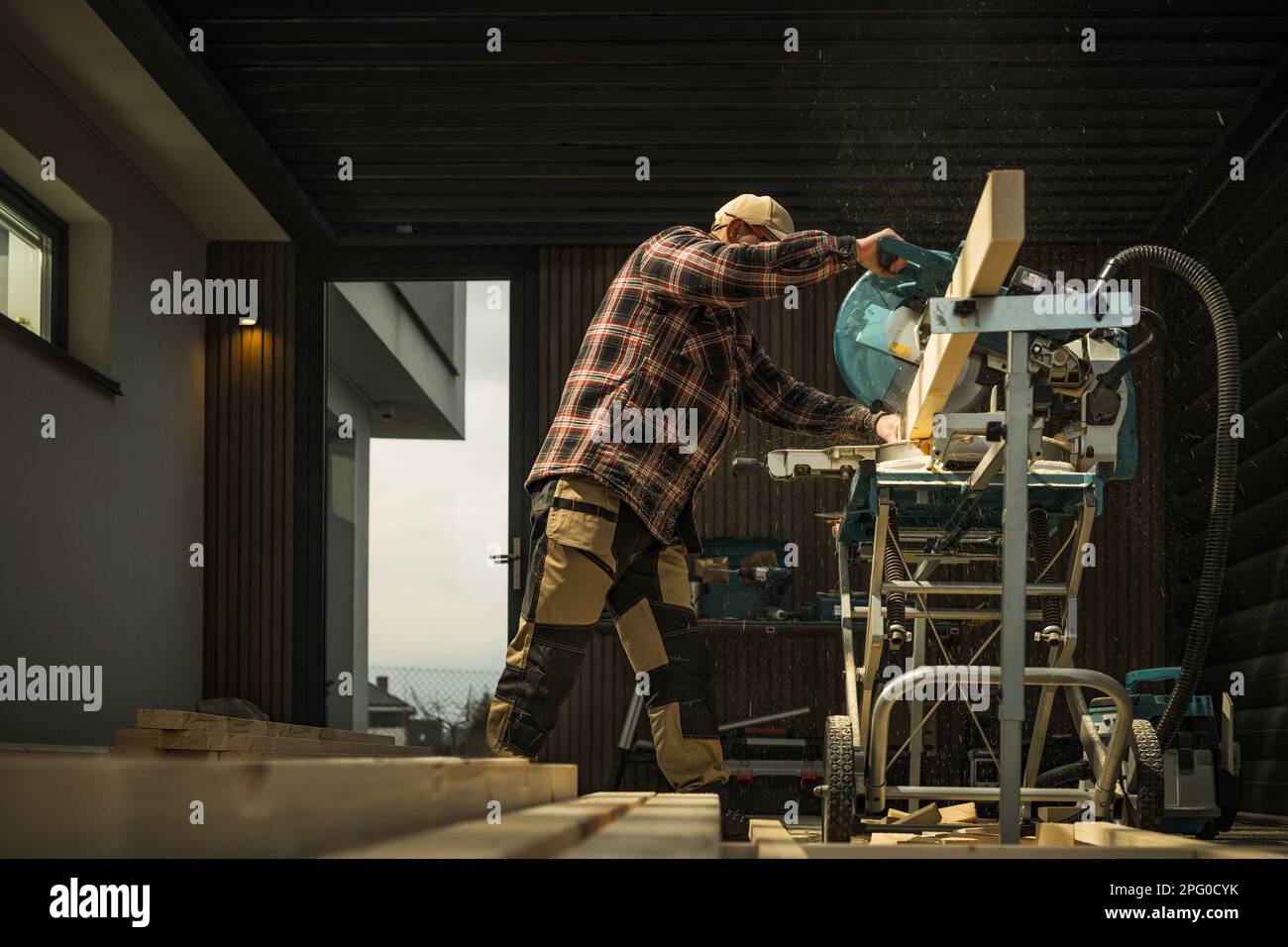 Small Architecture Woodwork Project. General Construction Worker Cut Wood Material To Size using Powerful Saw Machine. Stock Photo