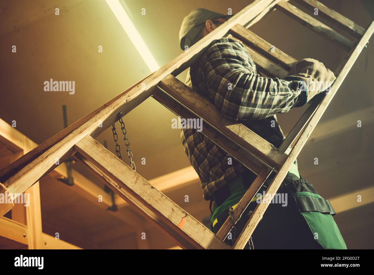 Caucasian Worker Moving Small Wooden Ladder Inside His Shed Stock Photo