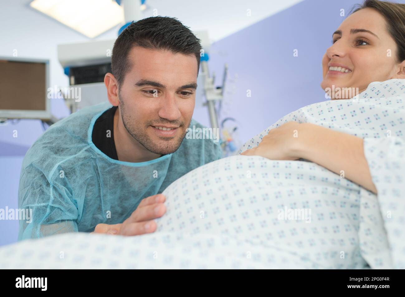 husband looking lovingly at wifes bump during childbirth Stock Photo