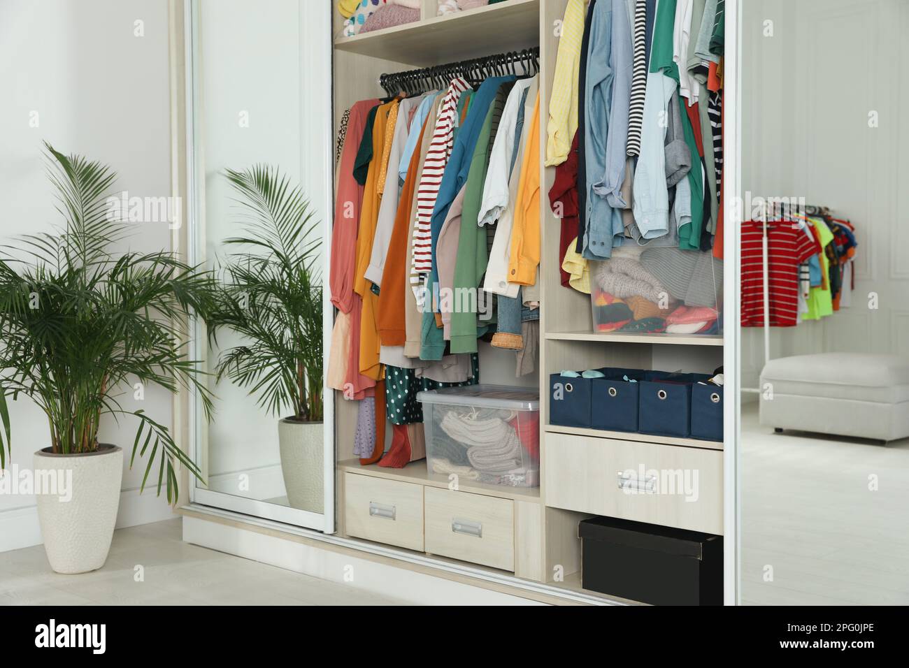 Wardrobe closet with different stylish clothes and home stuff in room ...
