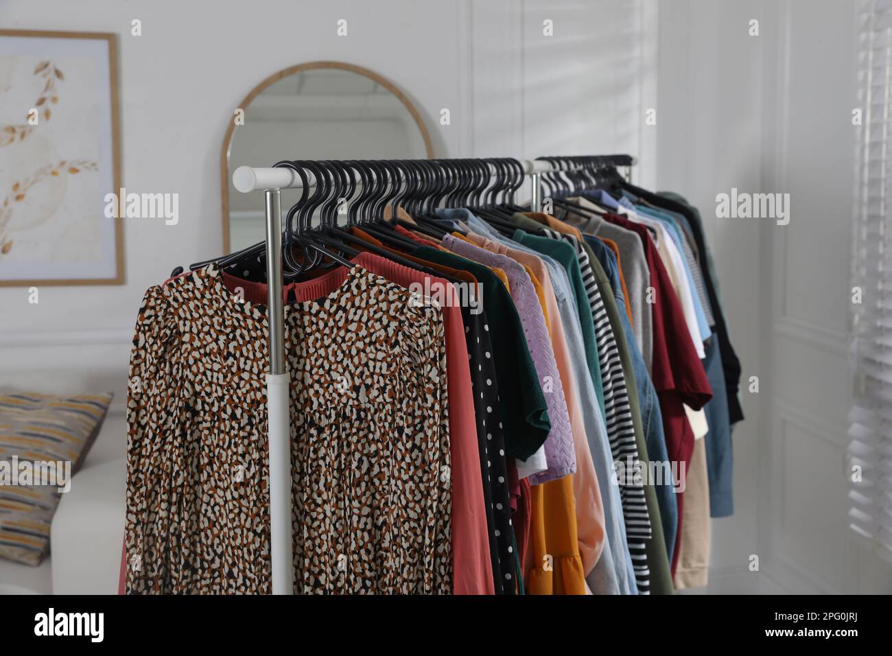 Rack with stylish clothes indoors. Fast fashion Stock Photo