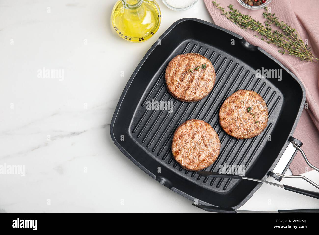 Skalk kanaal twaalf Grill pan with tasty fried hamburger patties and seasonings on white marble  table, flat lay. Space for text Stock Photo - Alamy