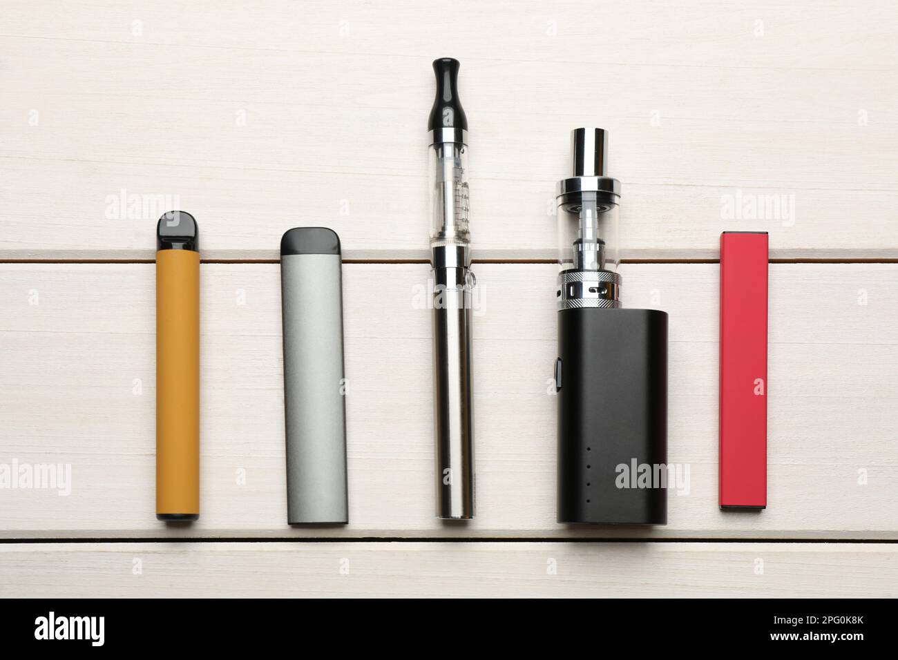 Different electronic cigarettes on white wooden table, flat lay. Smoking  alternative Stock Photo - Alamy