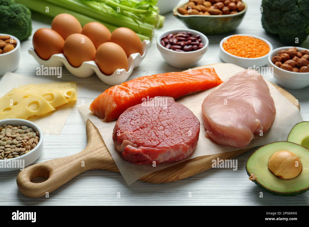 Fresh meat and other products on white wooden table. Sources of