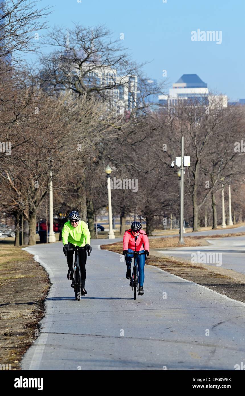 Chicago, Illinois, USA. Two cyckists pedal along a path near 31st Street Harbor on the Chicago lakefront on the city's South Side. Stock Photo
