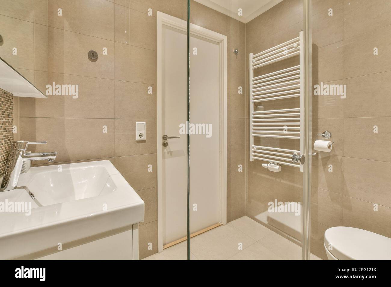 a bathroom with a toilet, sink and towel rack in the shower stall door