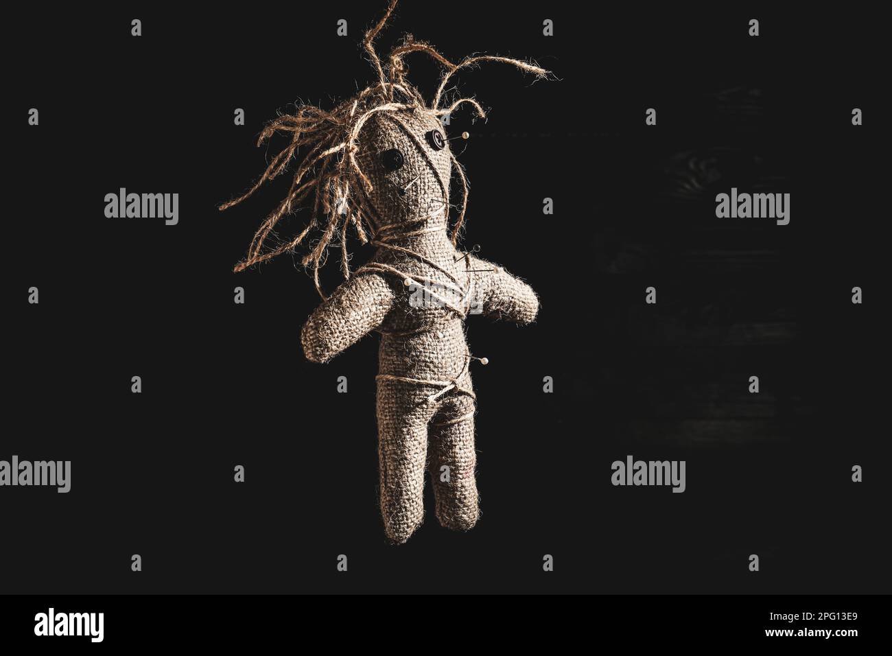 Female voodoo doll with pins on dark background Stock Photo - Alamy