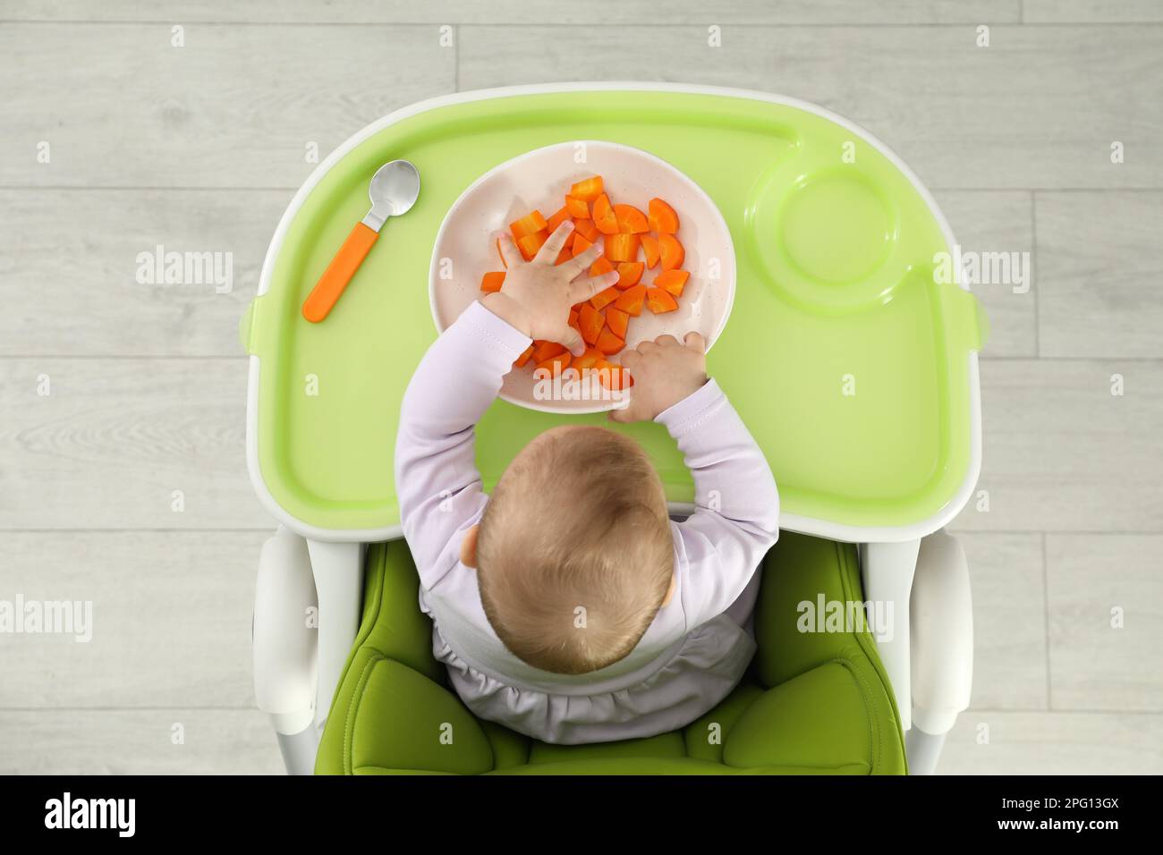 Cute little baby eating carrot, top view Stock Photo Alamy