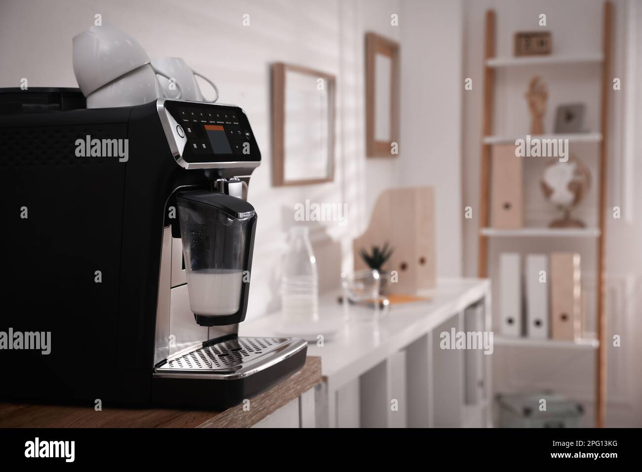 Modern coffee machine on table in office. Space for text Stock Photo