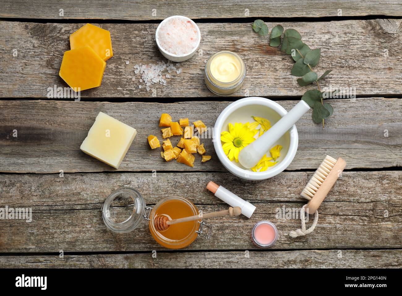 Flat lay composition with beeswax and cosmetic products on wooden table ...
