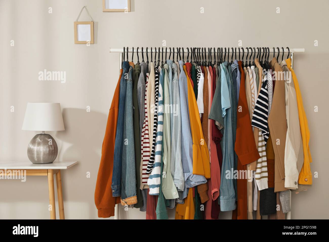 Rack with stylish clothes indoors. Fast fashion Stock Photo