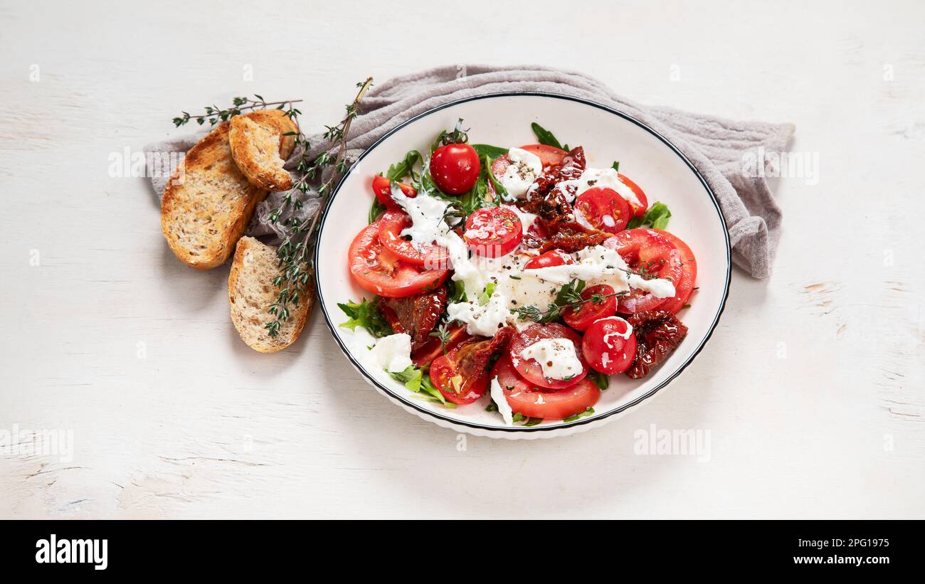 Tomato, basil, mozzarella. Caprese salad with olive oil. Top view, white background. Stock Photo