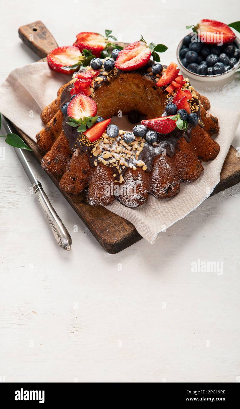 Bundt Cake with strawberry and berry on a light  background. Festive cake. Top view. Stock Photo
