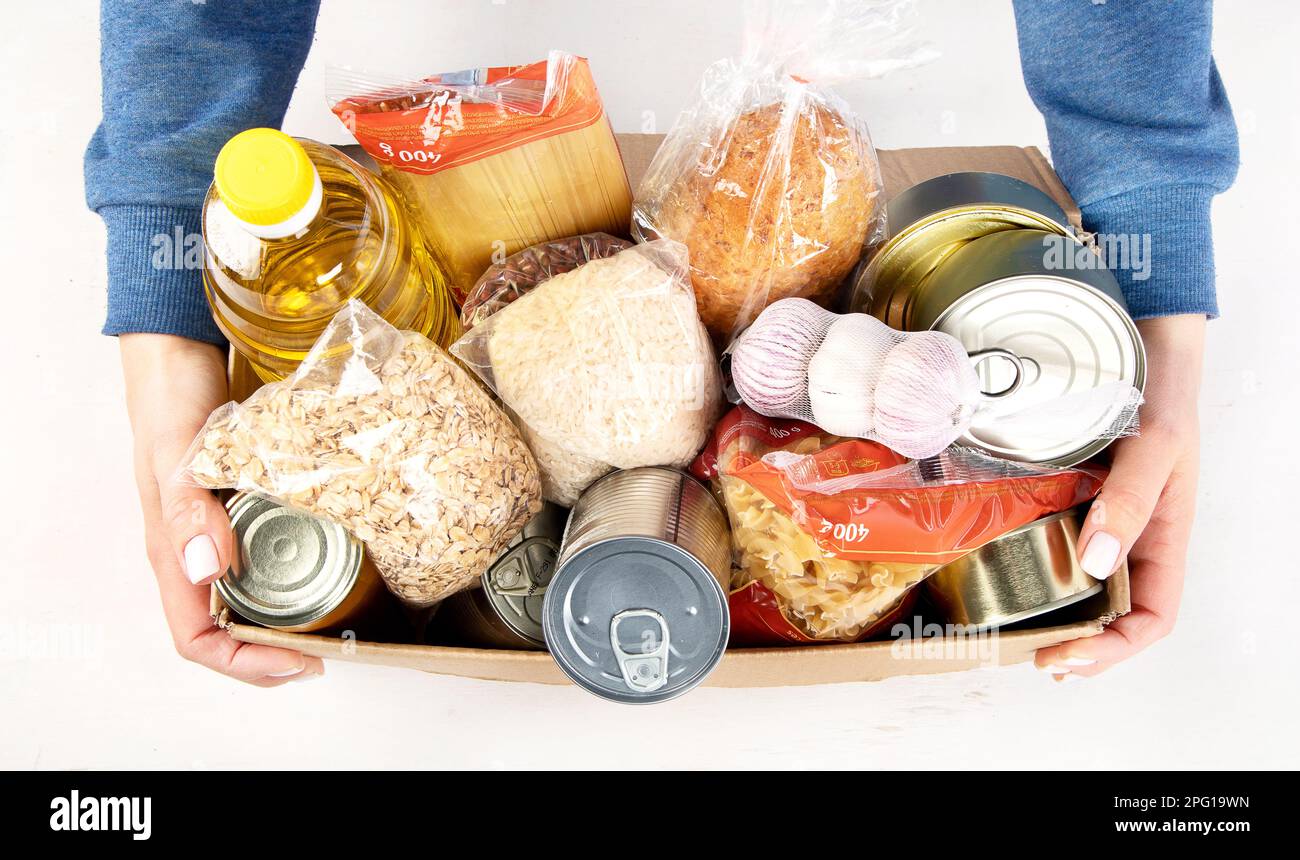 Food donation box of different products on light background, top view