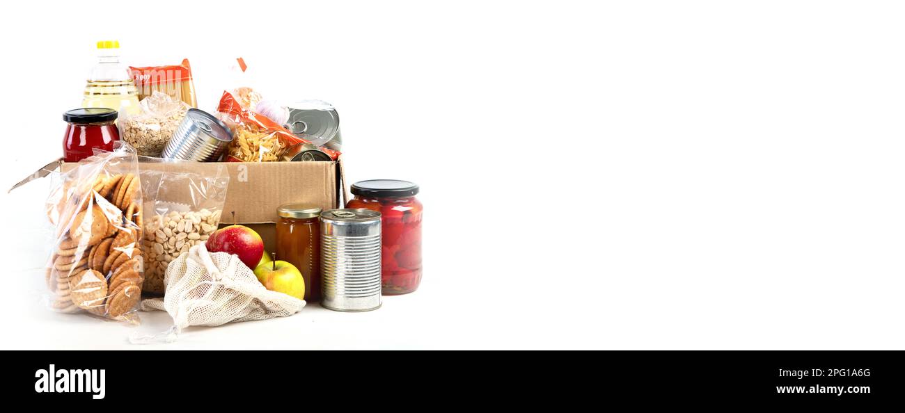 Food donation box of different products  on light background, top view. Food donations or delivery concept. Panorama, banner, copy space Stock Photo