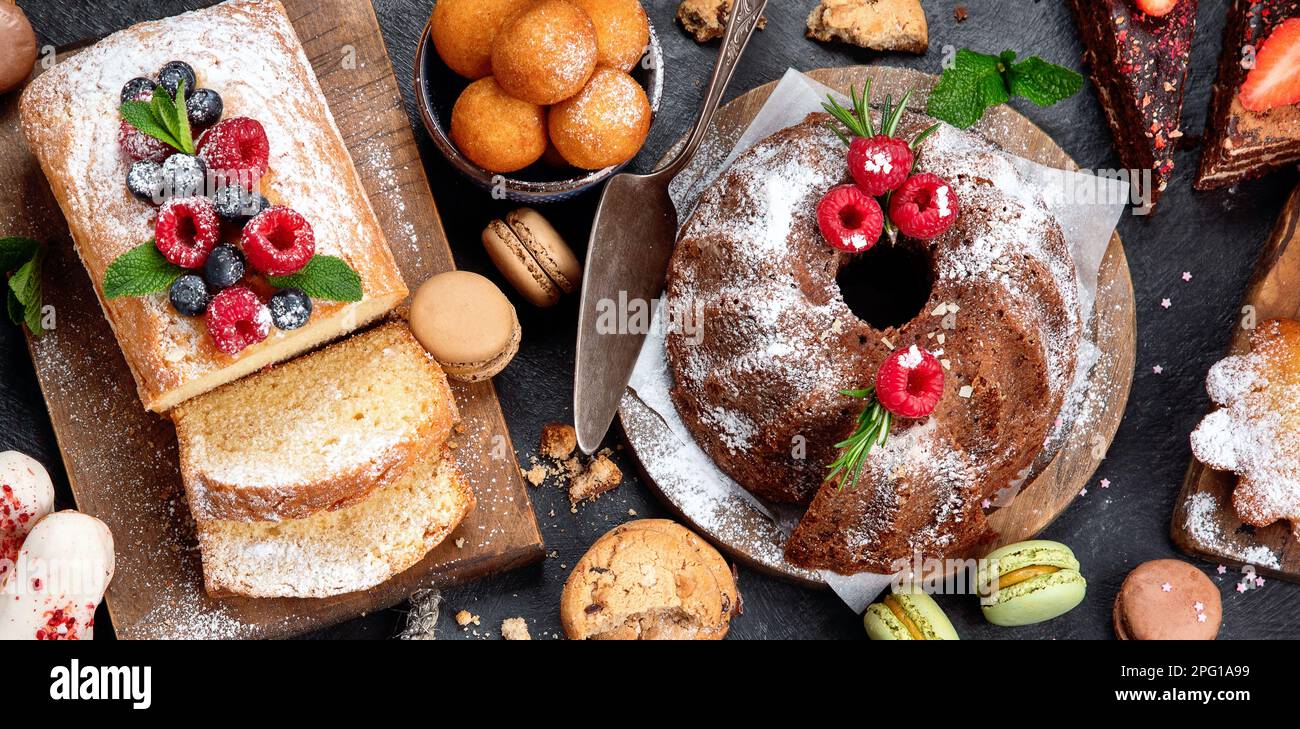 Different desserts on dark background. Delicious sweet dessert table with pound cake, chocolate and red velvet cakes. Holiday  sweet eating concept. T Stock Photo