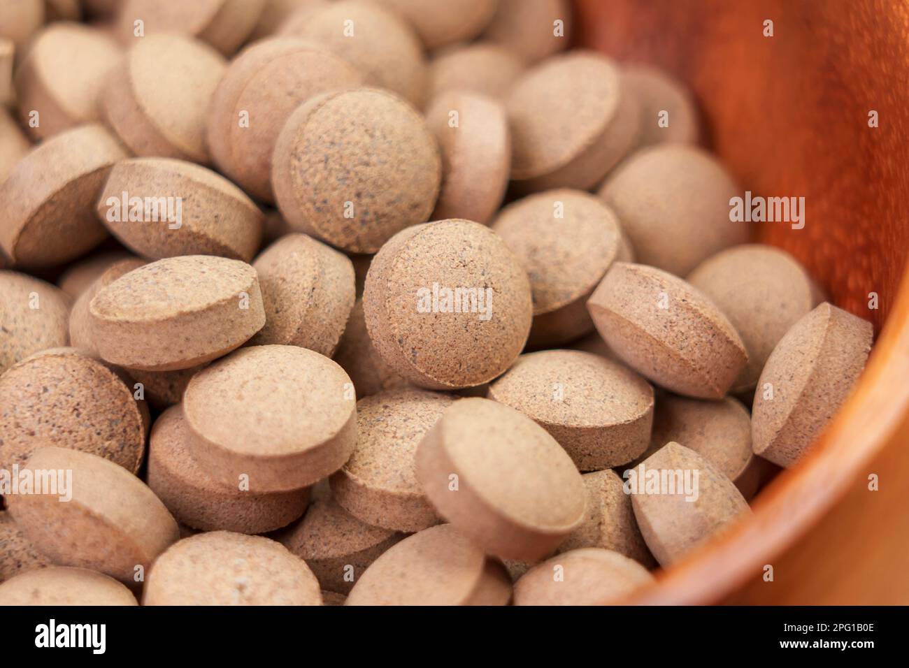 Brewer's yeast pills. Dietary supplement tablets in rustic wooden bowl