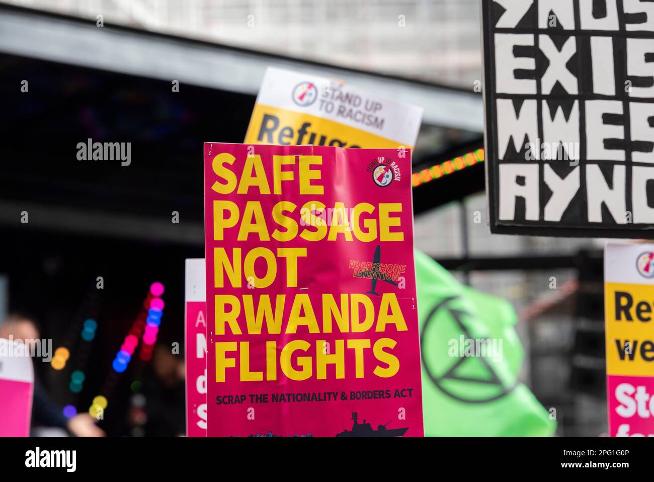 Protest taking place in London on UN Anti Racism Day. Stand up to Racism. Safe passage not Rwanda flights placard. Nationality and borders act Stock Photo