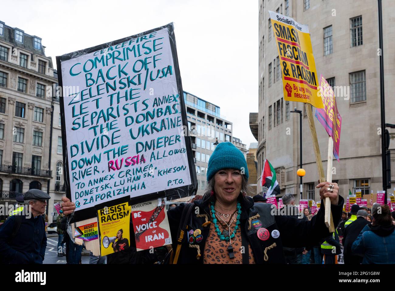 Protest taking place in London on UN Anti Racism Day. Stand up to Racism. Protester with placard with Ukraine war ceasefire, compromise message. Annex Stock Photo