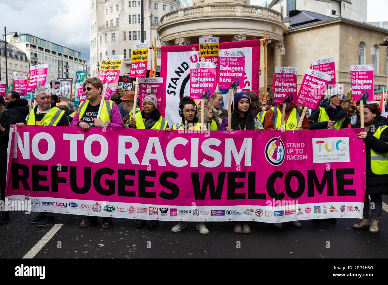 Protest taking place in London on UN Anti Racism Day. Stand up to Racism. No to racism, Refugees welcome banner and protesters Stock Photo