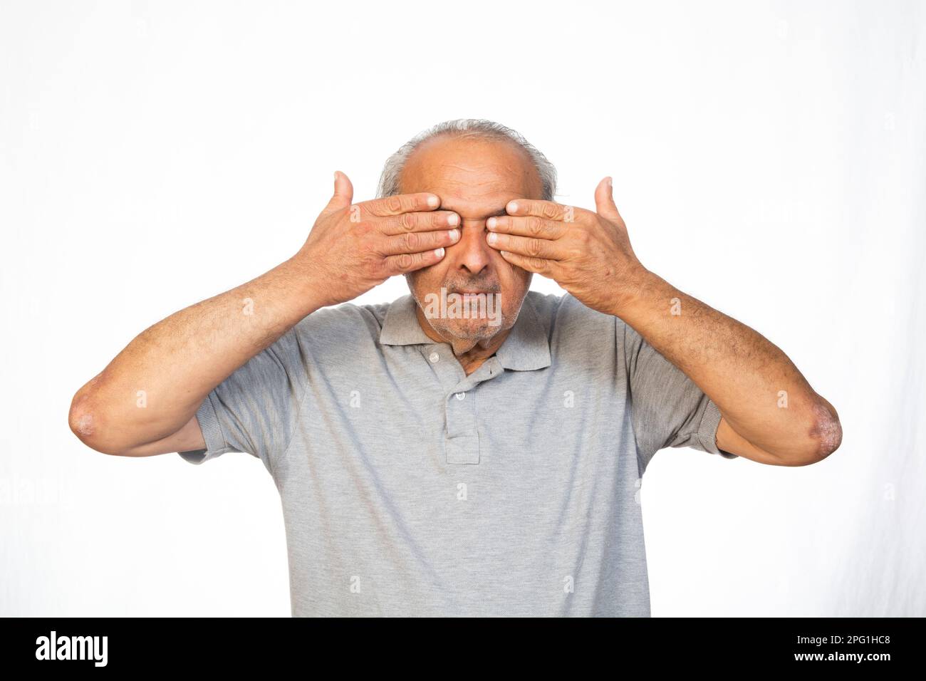 Old man covering his eyes Stock Photo