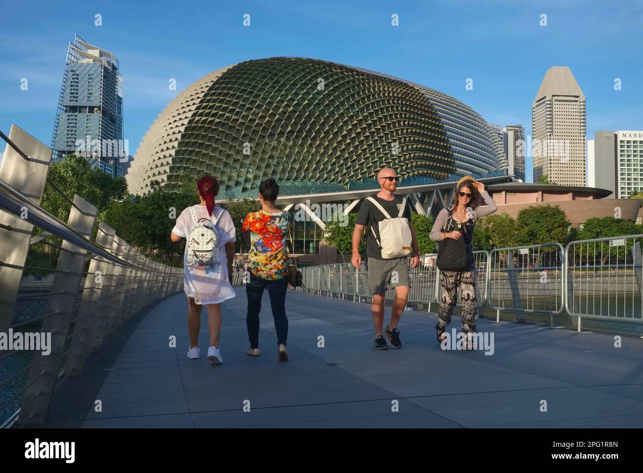 Foreign tourists walking on Jubilee Bridge over Marina Bay, Singapore, the iconic Theatres by the Bay - locally nicknamed 'The Durian' - in the b/g Stock Photo