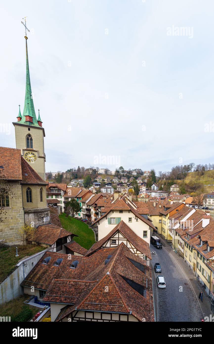 Bern, Switzerland - February 22, 2023: View of the Mattenenge street, and the Nydeggkirche church, with various buildings, locals, and visitors, in Be Stock Photo