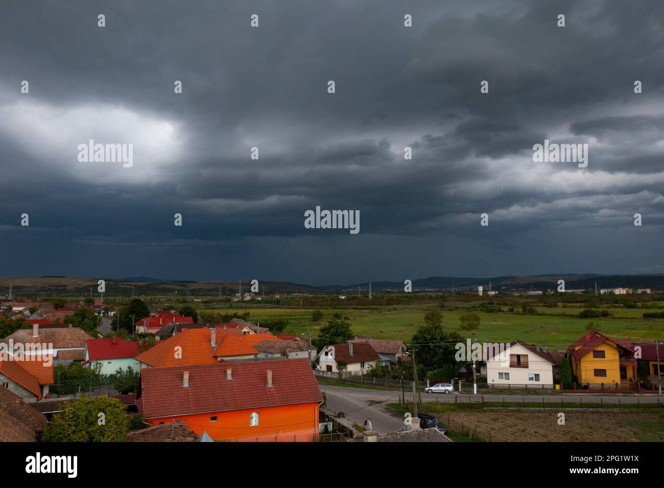 Aerial view of a small village with stormy sky in Transylvania, Romania. Stock Photo
