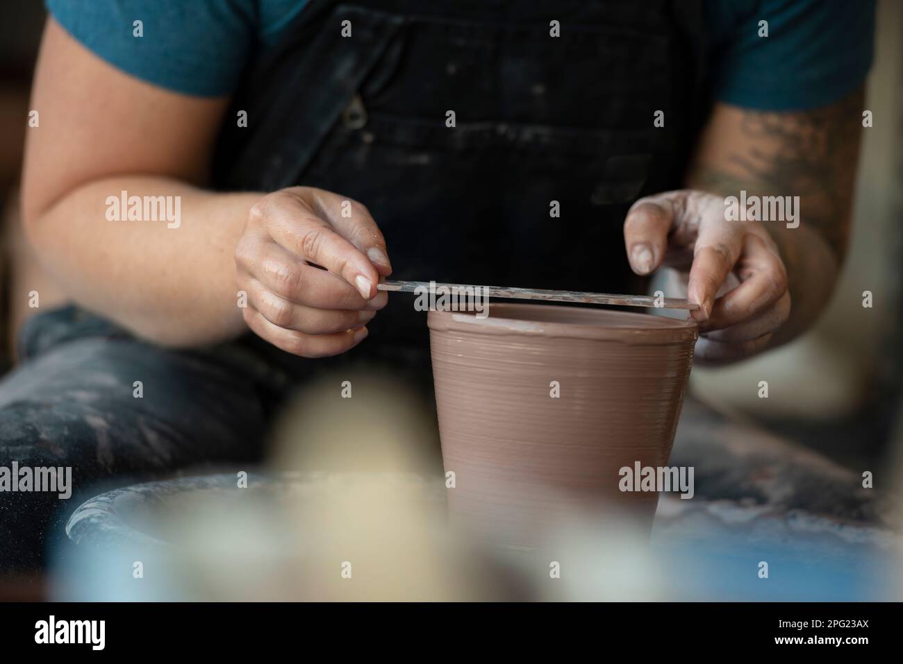 Potter crafting a pot on pottery wheel Stock Photo