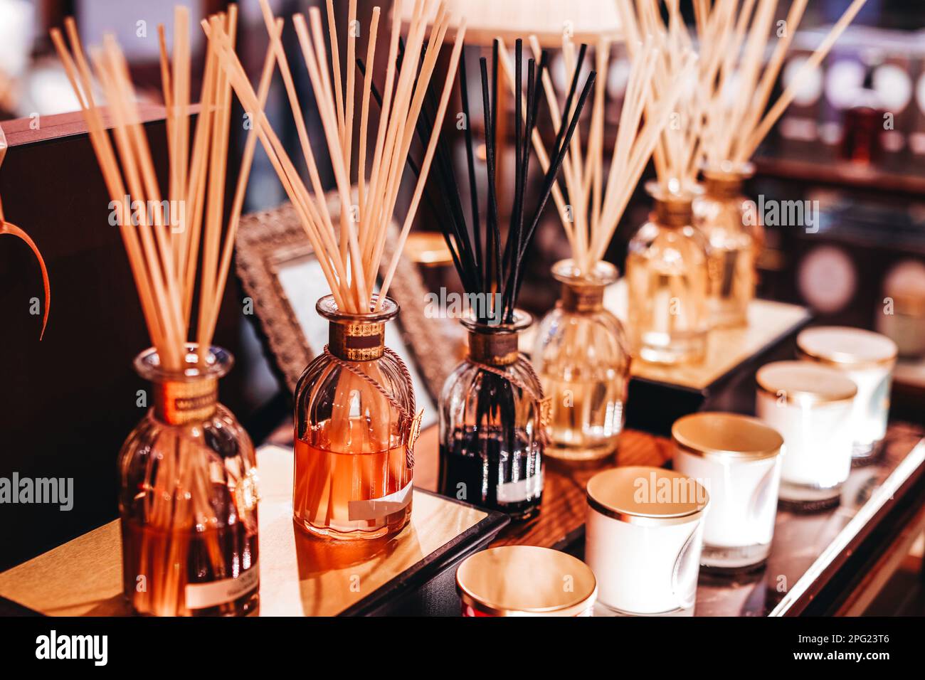 Mockup glass bottles with aroma sticks diffusers on wooden stand in the