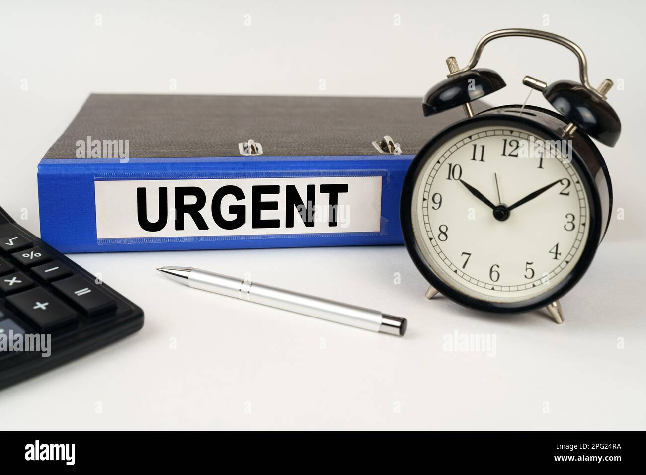 Business concept. On a white surface, an alarm clock calculator and a ...