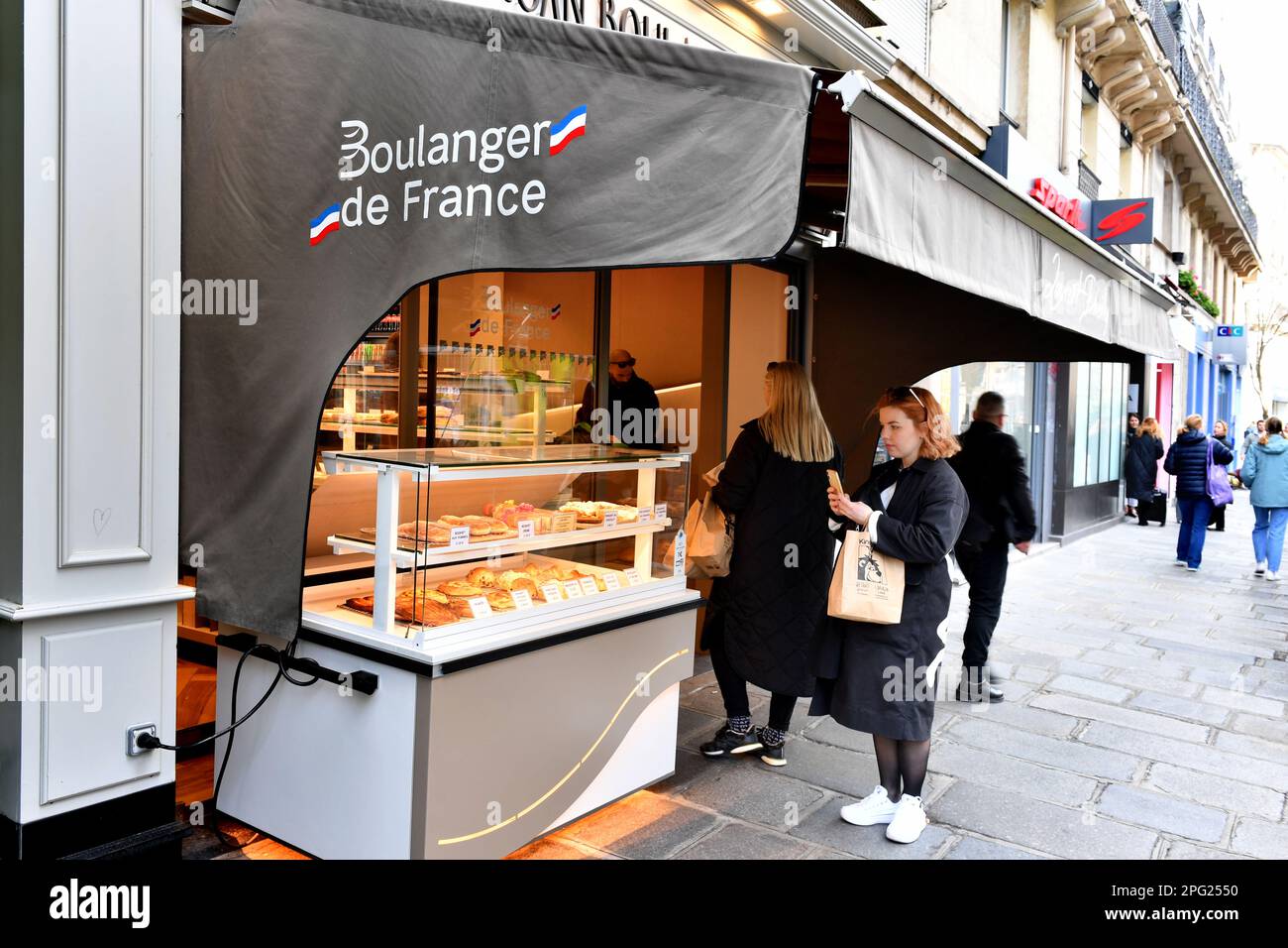 a street-facing display counter and awning of a French bakery