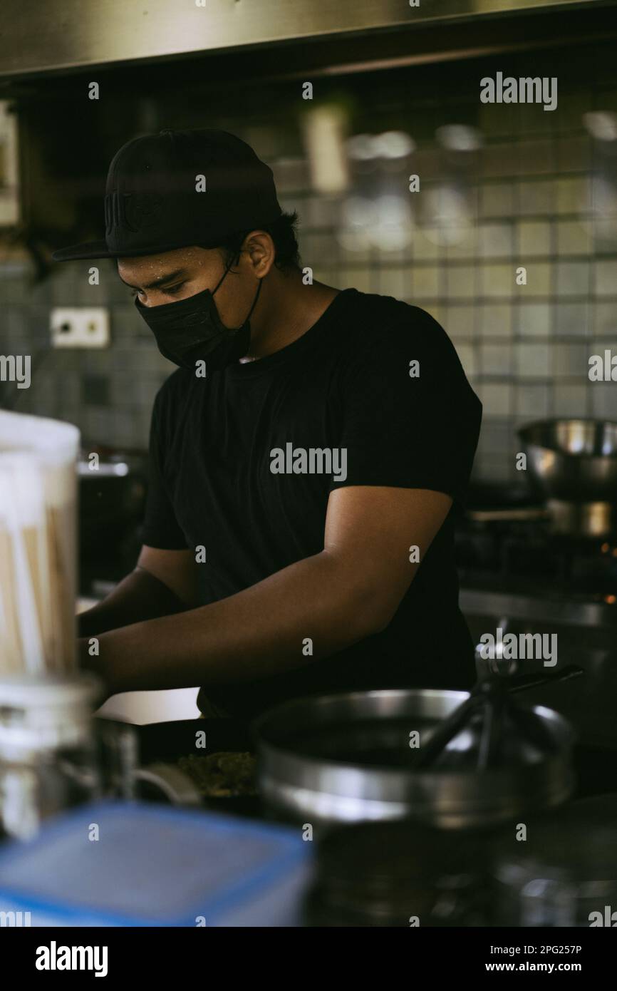 Asian man cooking in the restaurant kitchen. Stock Photo