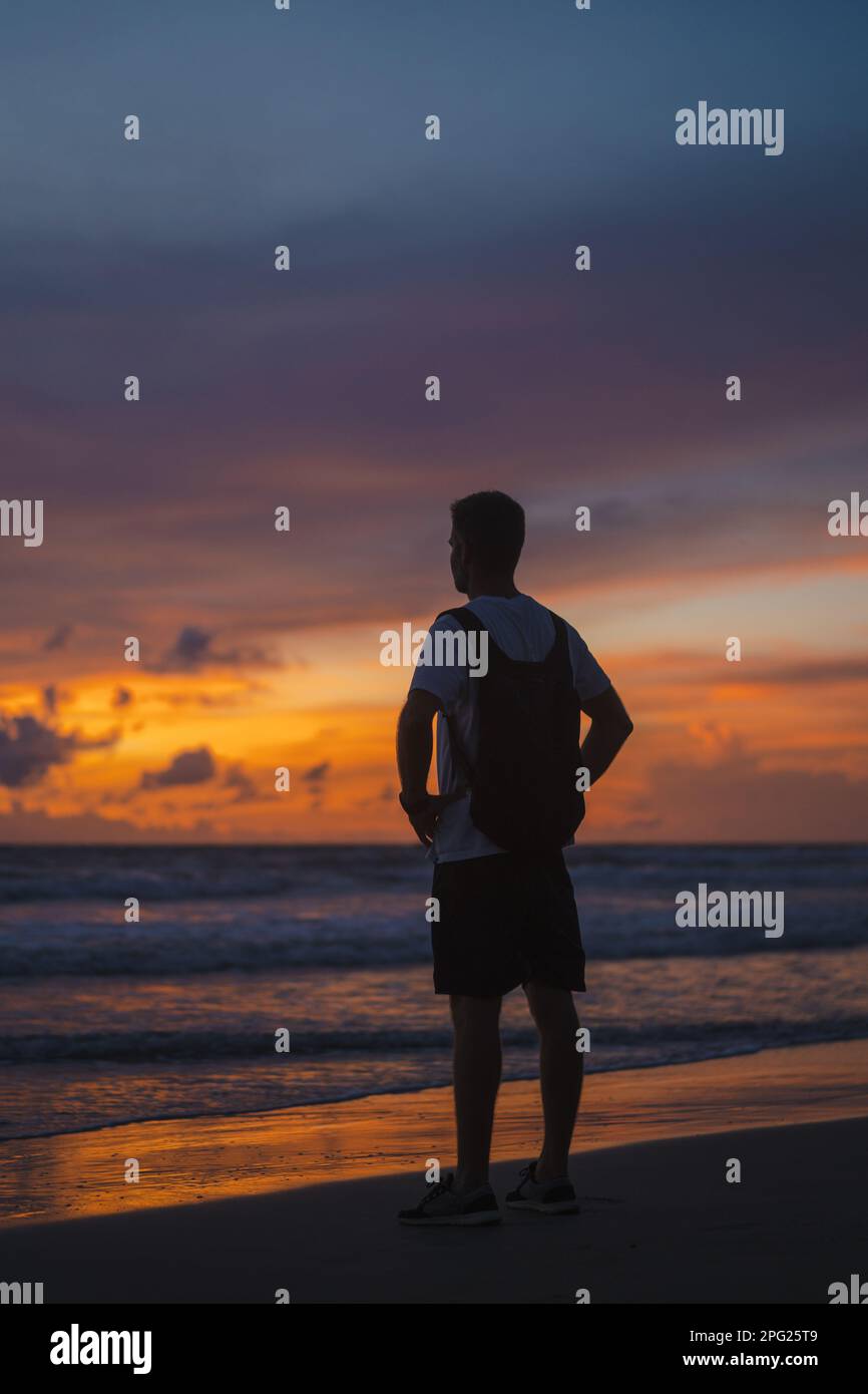 A man on the ocean watching the sunset. Film, grain Stock Photo - Alamy