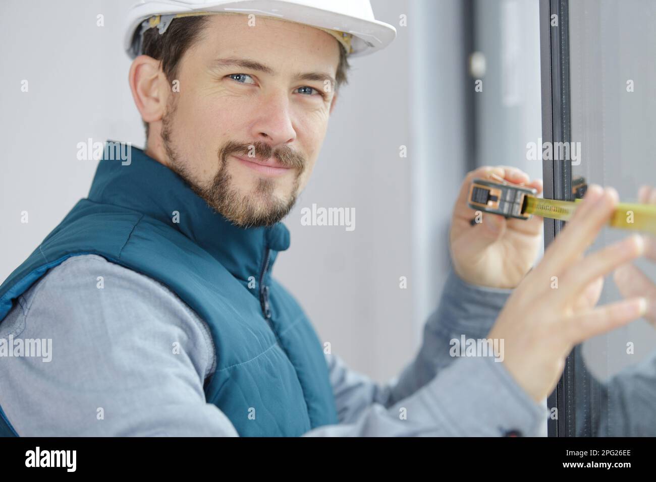 a male builder measuring window Stock Photo