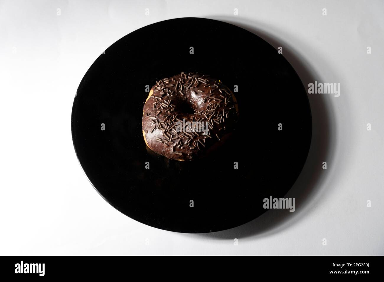 chocolate donut in black plate on white background. Top view Stock ...