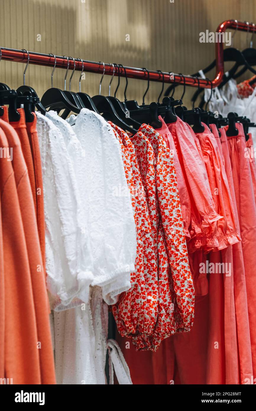 https://c8.alamy.com/comp/2PG28MT/pink-red-white-womens-clothes-dresses-hanging-on-a-hanger-in-a-row-fashion-collection-2PG28MT.jpg