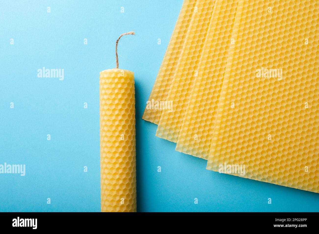Beeswax sheets and candles on blue background Stock Photo Alamy