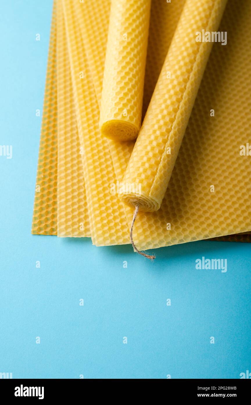 Beeswax sheets and candles on blue background Stock Photo Alamy